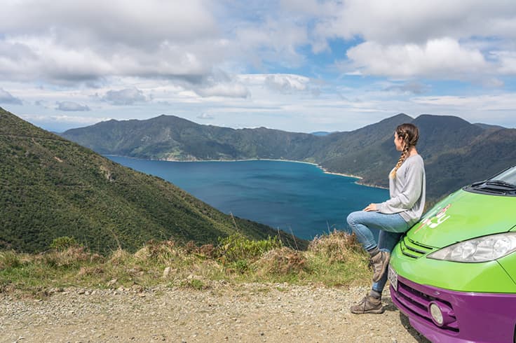 A girl looking at nature outside her JUCY campervan