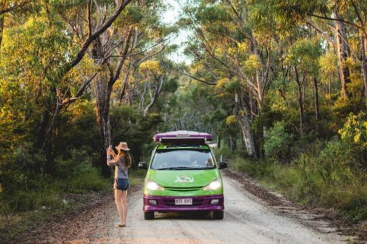 best time of year to visit australia 2 girl stops to take photo in front of jucy van raod tripping in australia