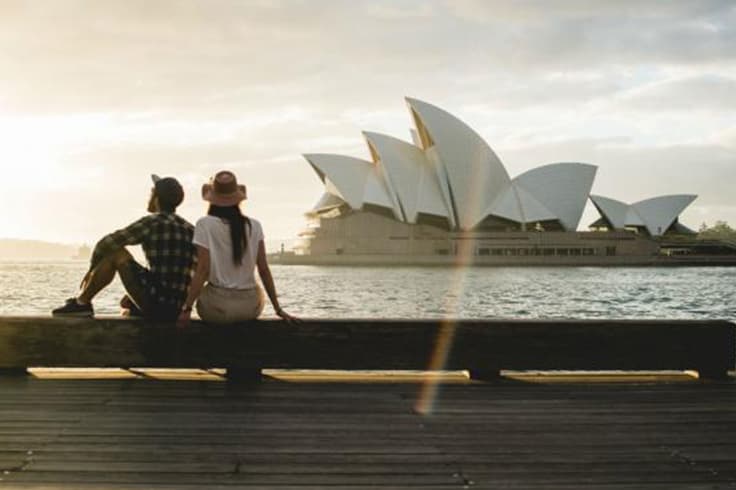 brisbane to sydney road trip itinerary 5 couple sit in front of opera house