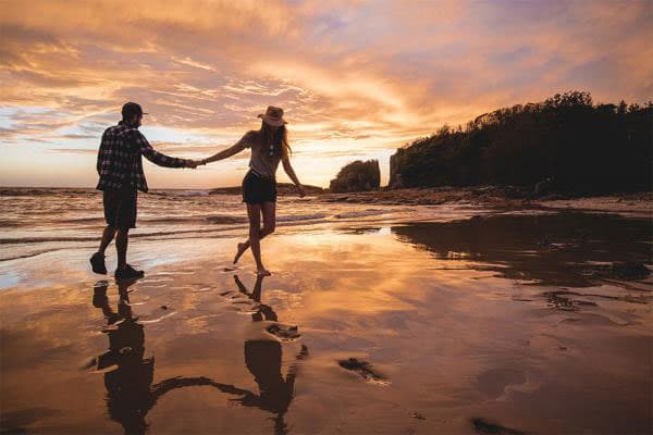 couple walk on a beach in australia at sunset couple-walk-beach-australia-at-sunset