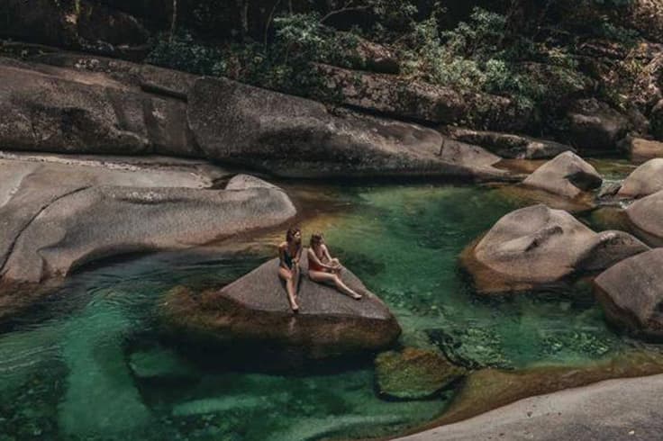 11 highlights from a road trip in tropical north queensland 7 2 girls sitting on a rock in natural pools