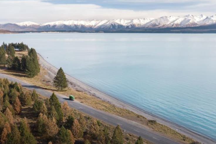 JUCY camper driving alongside snowy mountains JUCY camper driving alongside snowy mountains
