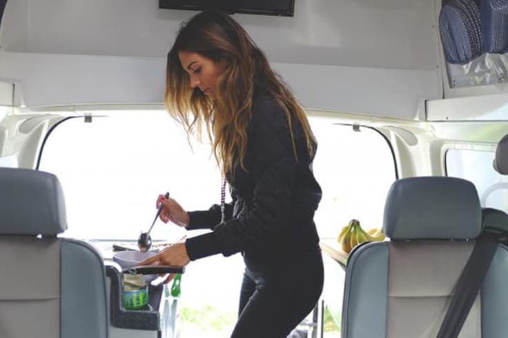 What to pack for the ultimate kiwi road trip Girl cooking in campervan